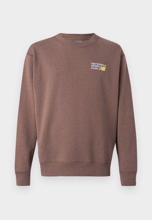 Rudas vilnonis džemperis su apvalia iškirpte, ribinėmis rankogaliais ir liemene. Priekinėje pusėje baltos ir geltonos spalvos logotipas „new balance athletic shoes“.