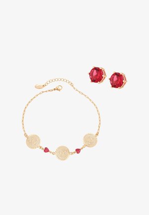 Goldkettchen-Armband mit drei runden, gravierten Münzen und zwei kleinen roten, herzförmigen Steinen, kombiniert mit runden roten Edelstein-Ohrsteckern.