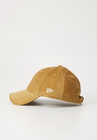 Brown corduroy baseball cap with a curved visor, embroidered logo on the front, and an adjustable strap at the back.