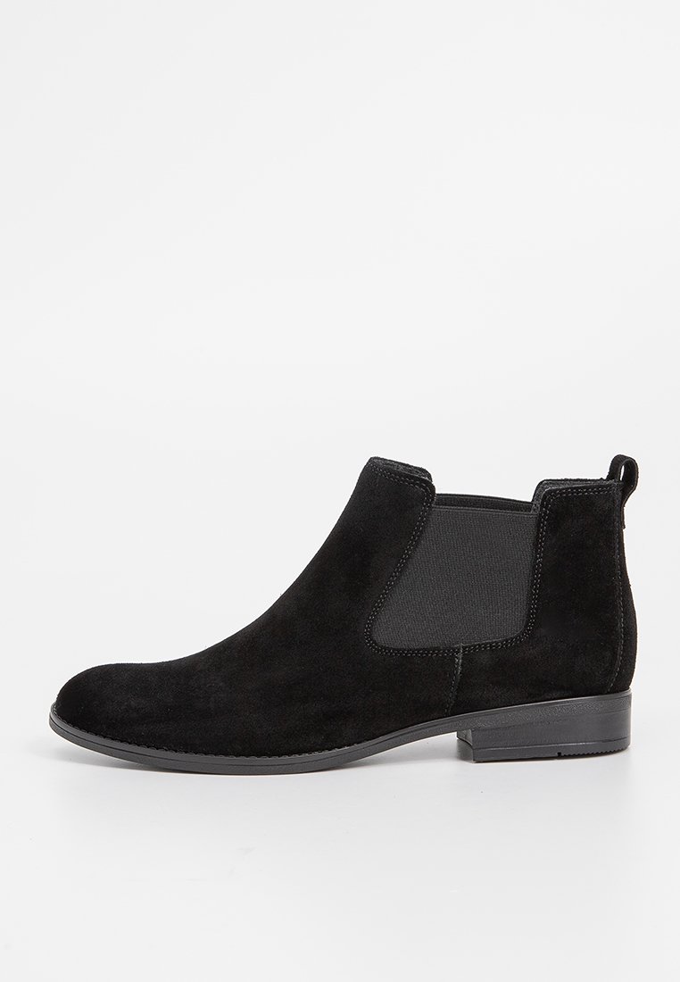 Schwarze Wildleder-Stiefelette mit elastischen Seiteneinsätzen, minimaler Nahtverarbeitung und einem niedrigen Absatz. Glatte Textur und reduziertes Design.