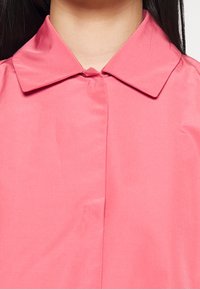 Roze overhemd met kraag, met een gladde textuur, knoopsluiting en minimalistisch ontwerp, op maat gemaakt voor een eigentijdse pasvorm.