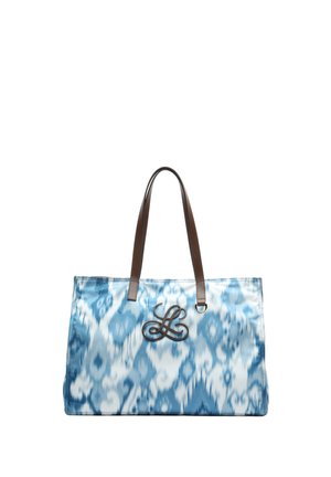 Vrečka za na ramo z modrim in belim vzorcem, rjavimi usnjenimi ročaji ter okrasnim logotipom z napisom, pritrjenim blizu zgornjega središča.