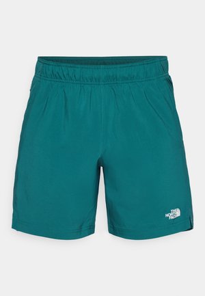 Shorts de sport de culoare teal, fabricate dintr-un material ușor, având o talie elastică și un mic logo alb pe partea stângă jos a piciorului.