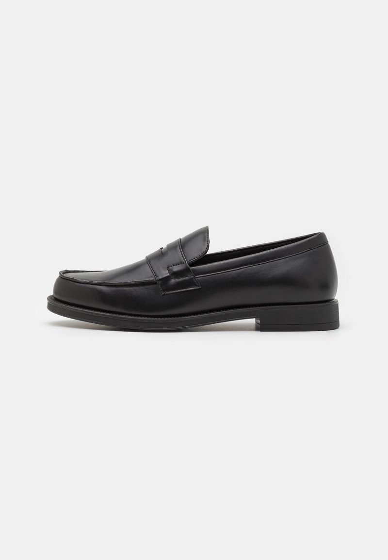 Mocassins de couro preto com um design elegante, com bico arredondado, detalhes costurados e um salto baixo bloco. Textura suave e mínimos acabamentos.