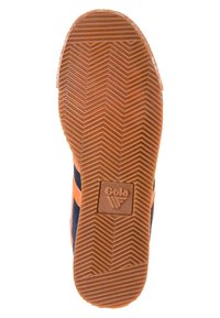 Suola in gomma marrone con motivo a zigzag, dotata di una piastra con logo. La scarpa presenta tomaia in tessuto blu navy con strisce arancioni.