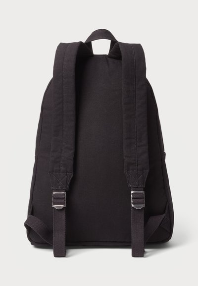 Rucsac din țesătură neagră cu o suprafață texturată, curele reglabile și o mânere superioară întărită. Design simplu și funcțional, fără ornamente.
