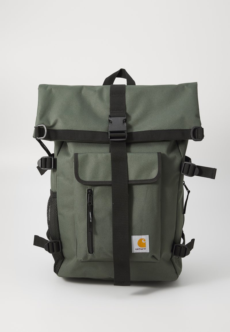 Zaino roll-top verde oliva con spallacci neri, una tasca frontale con zip, tasche laterali in rete e un'etichetta con logo. Realizzato in tessuto resistente.