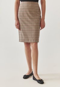 Délka po kolena, přiléhavá tužková sukně s výrazným houndstooth vzorem v odstínech růžové a béžové. Hladká látka s mírným leskem.