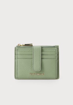 Green leather wallet with a textured finish, featuring a snap closure, multiple card slots, and a gold logo detail. Zippered compartment on top.