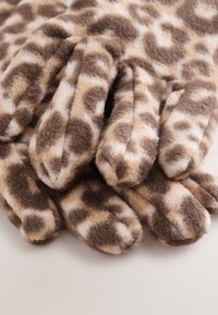 Handschoenen met luipaardprint, gemaakt van zacht, pluche materiaal. Ze hebben een bruin en beige kleurenschema met duidelijke vlekken en afgeronde punten.