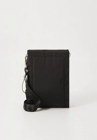 Black nylon crossbody bag with a rectangular shape, stitched detailing, adjustable strap, and zip closure. Smooth texture, minimal design.