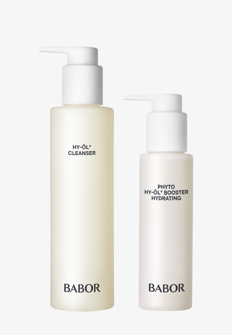 Deux flacons-pompe : un transparent avec une pompe blanche étiqueté "HY-ÖL® CLEANSER" et un autre blanc givré également avec une pompe blanche étiqueté "PHYTO HY-ÖL® BOOSTER HYDRATING".