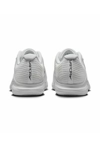 Las zapatillas deportivas blancas presentan una parte superior de malla texturizada con un diseño de talón acanalado. El logo está impreso en el talón, realzando el detalle visual.