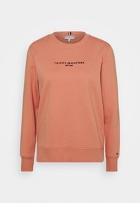 Sudadera en color coral con mangas largas, cuello redondo y puños y dobladillo acanalados. Presenta el logo "TOMMY HILFIGER EST. 1985" en negro en el pecho.