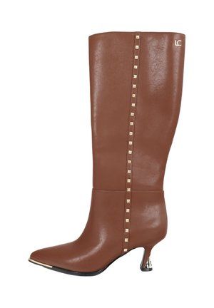 Bota marrón de cuero hasta la rodilla con punta puntiaguda, tachuelas doradas a lo largo del lateral y un pequeño detalle metálico en el tacón.