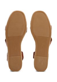 Brown rubber sandals with textured soles, featuring wide straps and a jute accent. Brand name "Tommy Hilfiger" printed on the sole.