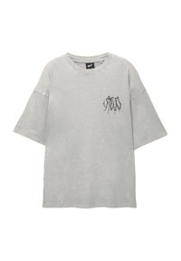 T-shirt grigio oversize realizzato in morbido cotone con una finitura usurata. Presenta un collo rotondo e una piccola grafica nera sul petto.