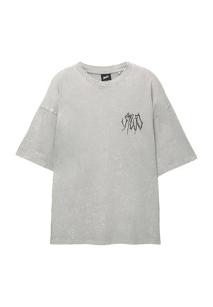 Överdimensionerad grå T-shirt i mjuk bomull med en sliten finish. Har rund halsringning och en liten svart grafik på bröstet.
