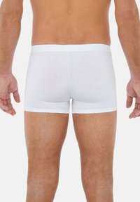 Weiße Baumwoll-Boxershorts mit engem Sitz, die eine glatte Textur und einen elastischen Bund oben aufweisen. Rückansicht gezeigt.