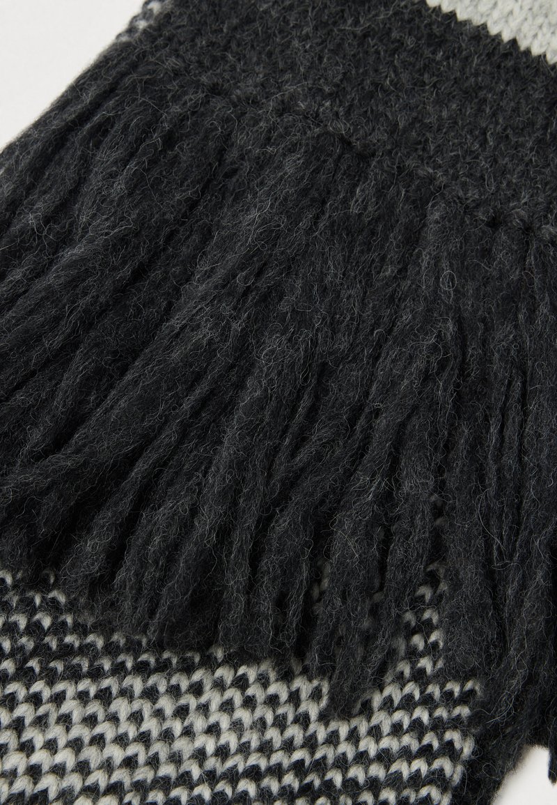 Sciarpa nera in maglia con orlo frangiato, caratterizzata da una finitura testurizzata e un motivo geometrico bianco a contrasto. Materiale morbido in misto lana.