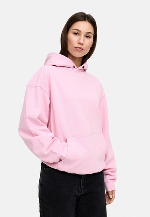 Pink hooded sweatshirt with a front pocket, relaxed fit, and long sleeves. Black drawstring and ribbed cuffs enhance functionality.