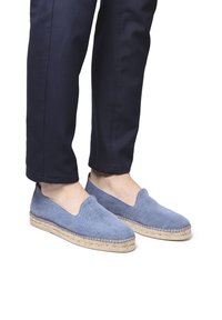 Espadrillas blu in tela con suola in juta, design slip-on e dettagli di cucitura a vista. Indossate con pantaloni blu navy.