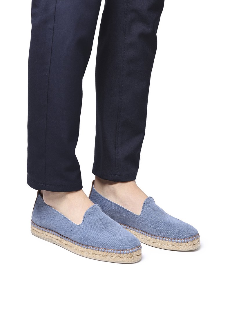 Espadrillas blu in tela con suola in juta, design slip-on e dettagli di cucitura a vista. Indossate con pantaloni blu navy.