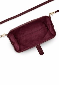 Bordo odinė per petį nešiojama rankinė su tekstūruota išorė, lygiu zomšiniu vidumi ir nuimamu diržu. Turėti plokščią dugną ir užtrauktuko uždarymą.