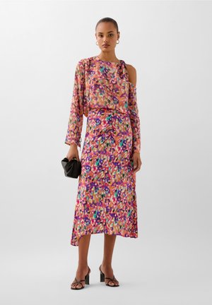 Abito colorato e fantasioso con maniche lunghe, spalla asimmetrica e dettagli arricciati. Realizzato in tessuto leggero con tonalità vivaci di rosa, viola e verde.