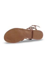 Semelle en caoutchouc marron avec des rainures ; la tige présente des sangles à imprimé léopard clair et des accents en métal doré. Le design comprend des boucles ajustables.