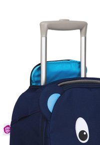 Navyblaue Kindertasche mit Bärenmotiv, ausgestattet mit einem teleskopierbaren Metallgriff und einem leuchtend blauen Innenraum. Mit Reißverschluss-Fach.