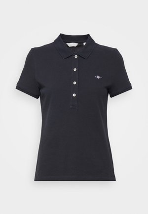 Navy blue polo shirt with short sleeves, three-button placket, and a small logo on the left chest. Made of cotton with a smooth texture.