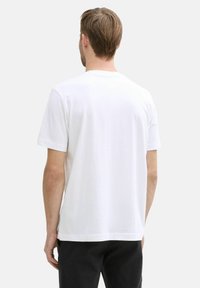 Weißes Baumwoll-T-Shirt mit kurzen Ärmeln, geradem Saum und einfachem Design. Keine sichtbaren Grafiken oder Muster. Rückansicht.