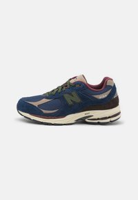 New Balance running shoe featuring navy suede and mesh upper, maroon accents, green laces, and a cushioned cream sole with black tread.