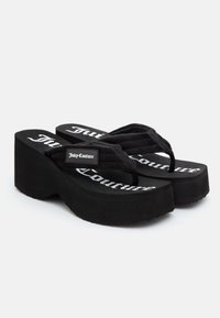 Black platform flip-flops with a textured sole, featuring a fabric strap and "Juicy Couture" logo in white on the footbed.