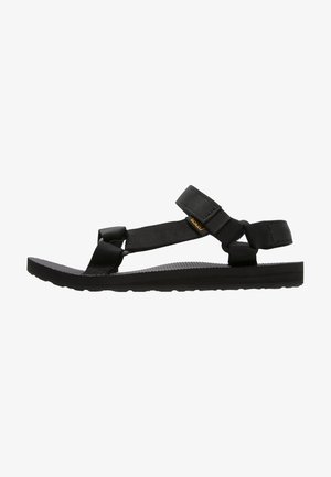 Black sandal featuring adjustable nylon straps and a textured rubber sole. Design prioritizes comfort, suitable for casual outdoor wear.