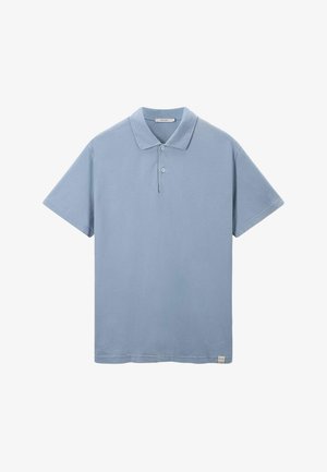 T-shirt polo bleu ciel en tissu doux, manches courtes, patte de boutonnage à trois boutons, et un design légèrement texturé avec une petite étiquette logo à l'ourlet.