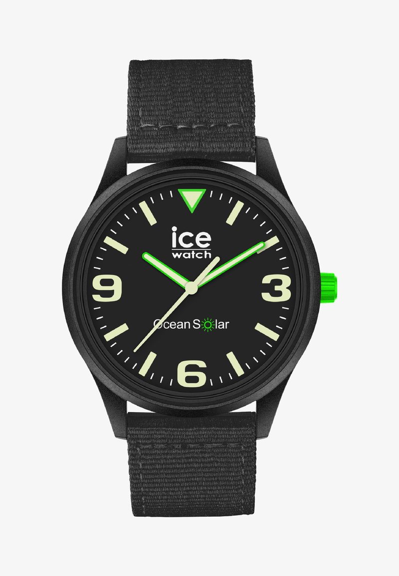 Svart analog klocka med texturerat armband, djärva vita siffror, lysande gröna visare och detaljer, samt en svart urtavla med "Ocean Solar."