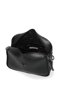 Černá kožená krosbody taška se zipem otevřeným, odhalující vnitřní látku s logem "MEXX" a štítkem s nápisem "Všechno to začalo polibkem."