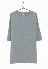 Harmaa neulemekko, jossa on vetoketju takana, kolme neljäsosaa hihan pituudesta ja suora leikkaus. Pehmeä tekstuuri ja minimalistinen muotoilu.