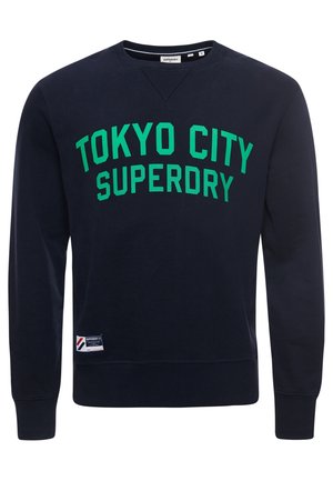 Marineblauer Sweatshirt mit Rundhalsausschnitt, grünem "TOKYO CITY SUPERDRY" Schriftzug und einem kleinen weißen Marken-Patch nahe dem Saum.