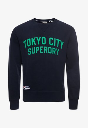 Mørkeblå crewneck sweatshirt med grøn "TOKYO CITY SUPERDRY" tekst og et lille hvidt mærke nær kanten.