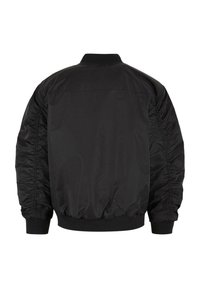 Jachetă bomber neagră cu o textură netedă și strălucitoare. Prezintă un guler și mansete cu nervuri, detalii plisate pe mâneci și o talie elastică.