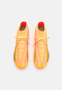 Scarpe da calcio gialle brillanti con accenti arancioni e dettagli neri. Materiale liscio, design alto e sistema di allacciatura tradizionale.