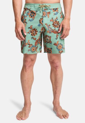 Herren-Badeshorts in Hellgrün mit einem Blumen- und Paisley-Muster in Orange und Blau, mit Kordelzugbund und einer Länge über dem Knie.