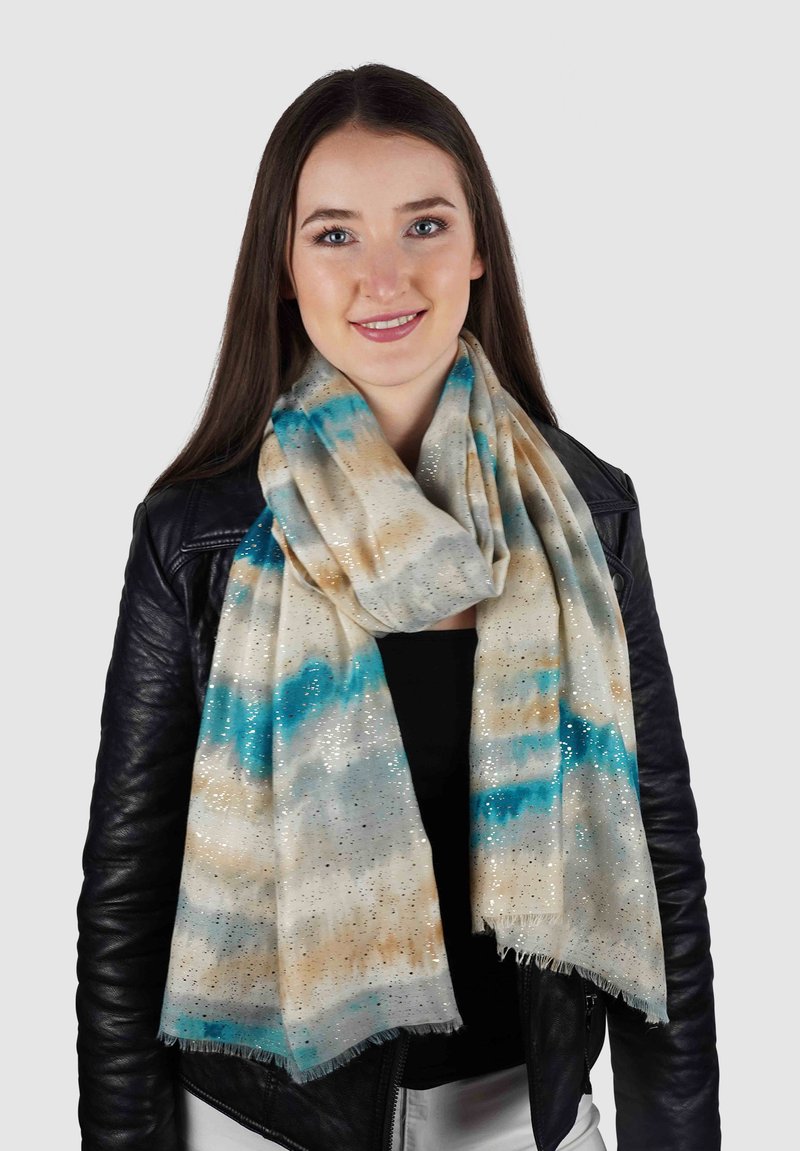 Lichtgewicht sjaal in crème met blauwe en tan aquarelstrepen, verrijkt met zilveren metallic accenten en franje randen.