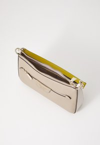 Borsa in pelle beige con finitura testurizzata, dotata di una cerniera gialla senape, chiusura superiore a zip e una tasca frontale con un sottile etichetta del marchio.