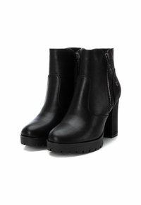 Botas de cuero negro hasta el tobillo con una suela de plataforma gruesa, tacón alto en bloque, cierre de cremallera lateral y detalle de panel elástico. Textura suave.