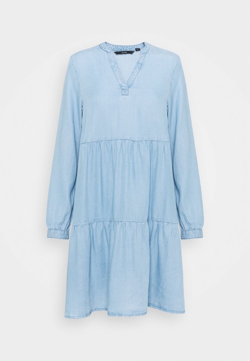 Robe décontractée bleu clair à manches longues avec jupe à volants et décolleté en V sur fond uni clair.