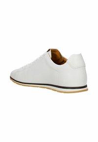 Baskets en cuir blanc avec doublure intérieure beige, bordure noire le long de la semelle, et semelle extérieure en caoutchouc marron clair, vues de côté et de l'arrière.